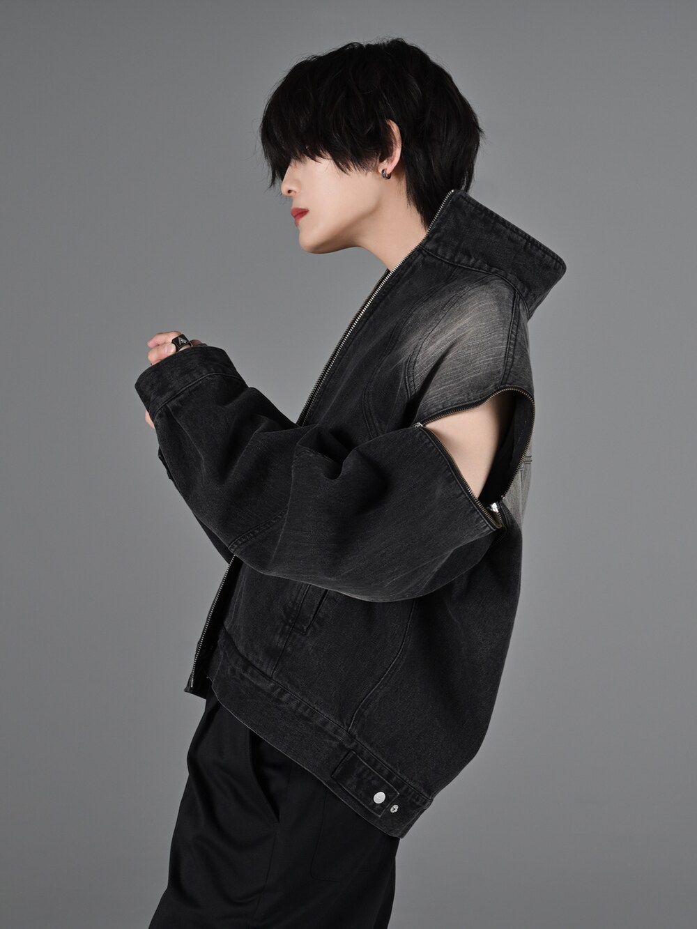 グレー系のタンクトップ、ブラック系のスラックス、ブラック系のブーツを着用したメンズの冬コーディネートの3枚目の写真