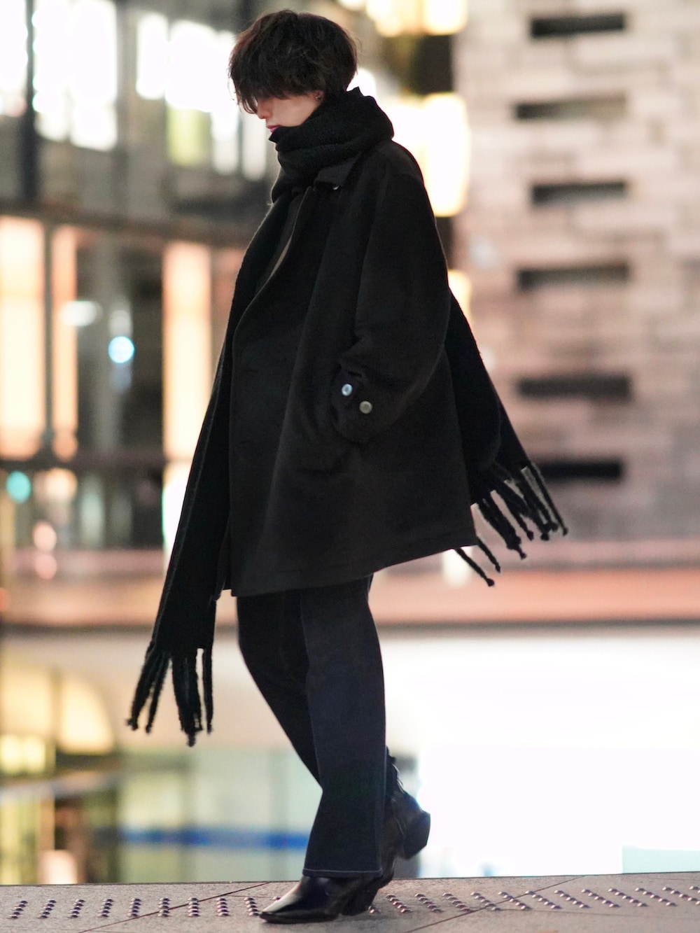 レッド系のニット/セーター、ブルー系のデニムパンツ、ブラック系のブーツを着用したメンズの秋コーディネートの2枚目の写真