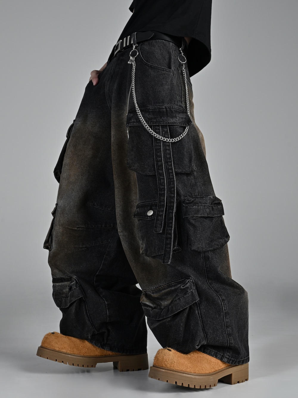 ベージュ系のブーツ、ブラック系のダウンジャケット/コート、ブラック系のカーゴパンツを着用したメンズの秋コーディネートの5枚目の写真