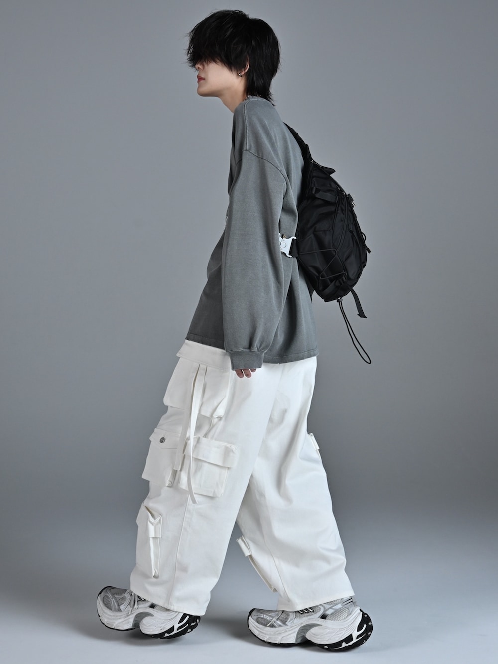 ホワイト系のスニーカー、グレー系のTシャツ/カットソー、ホワイト系のカーゴパンツを着用したメンズの秋コーディネートの2枚目の写真