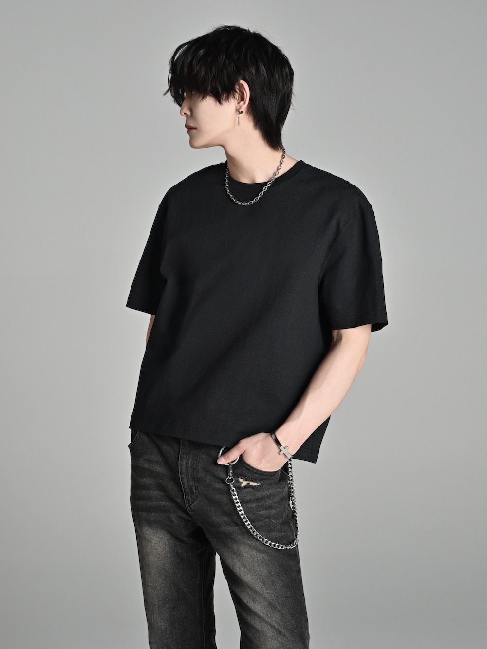 ブラック系のデニムパンツ、ブラック系のブーツ、ブラック系のTシャツ/カットソーを着用したメンズの春コーディネートの4枚目の写真