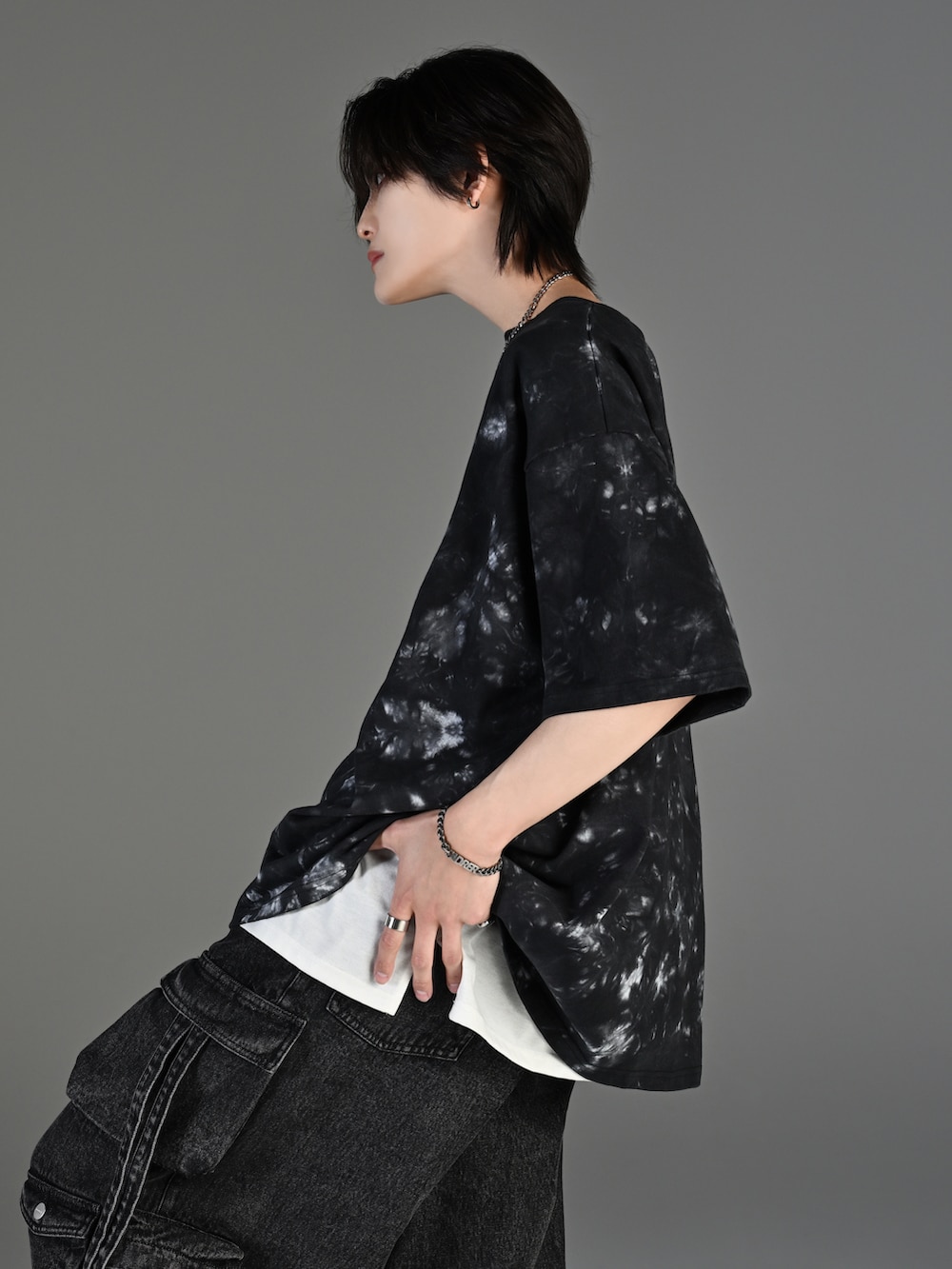 グレー系のタンクトップ、ブラック系のカーゴパンツ、ホワイト系のスニーカーを着用したメンズの春コーディネートの4枚目の写真