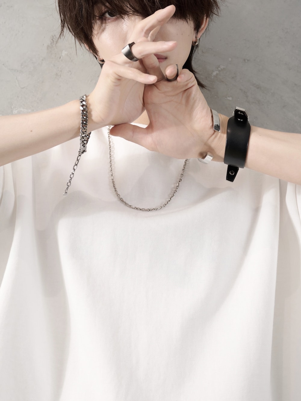 ブラック系のデニムパンツ、ホワイト系のTシャツ/カットソー、ブラック系のショルダーバッグを着用したメンズの春コーディネートの4枚目の写真