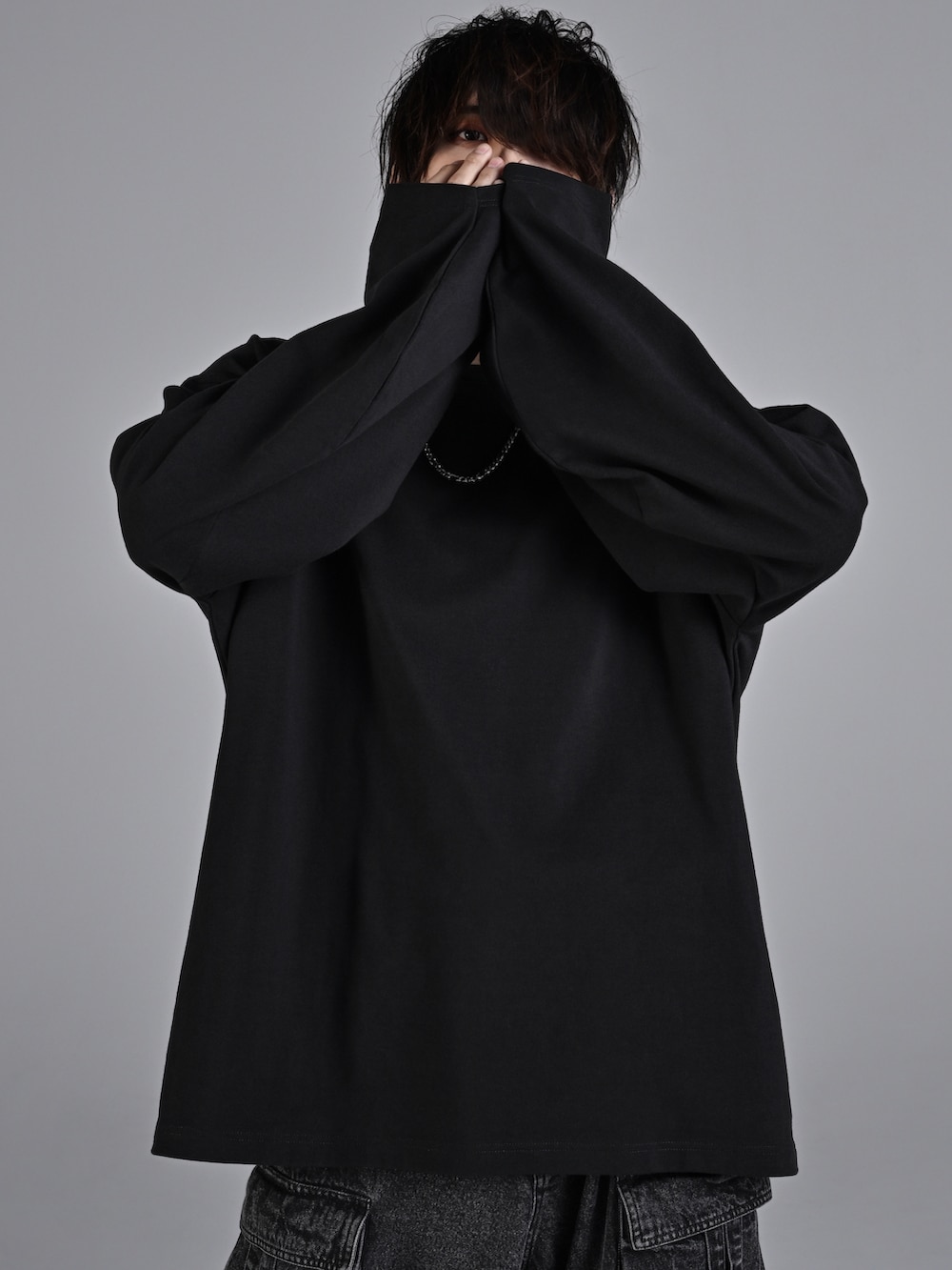 ブラック系のカーゴパンツ、ホワイト系のスニーカー、ブラック系のショルダーバッグを着用したメンズの秋コーディネートの3枚目の写真