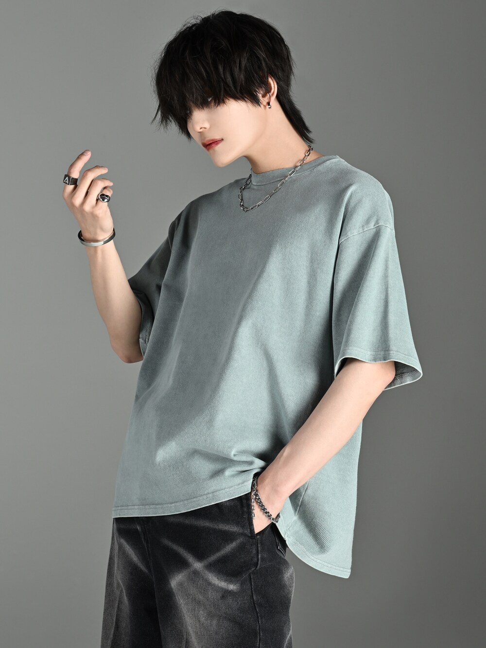 ブラック系のショルダーバッグ、グリーン系のTシャツ/カットソー、ブラック系のサンダルを着用したメンズの夏コーディネートの2枚目の写真