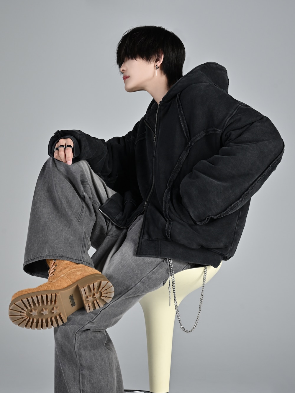 ベージュ系のブーツ、ブラック系のパーカー、グレー系のデニムパンツを着用したメンズの秋コーディネートの5枚目の写真