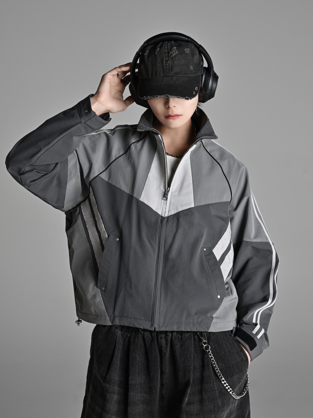 ブラック系のその他パンツ、グレー系のナイロンジャケット、ホワイト系のスニーカーを着用したメンズの冬コーディネートの2枚目の写真