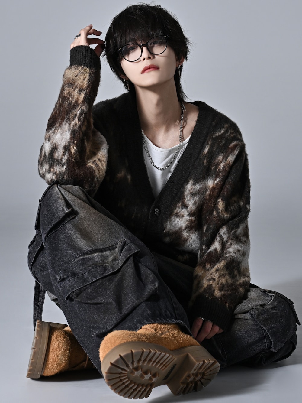 ブラウン系のカーディガン/ボレロ、ベージュ系のブーツ、グレー系のタンクトップを着用したメンズの秋コーディネートの2枚目の写真