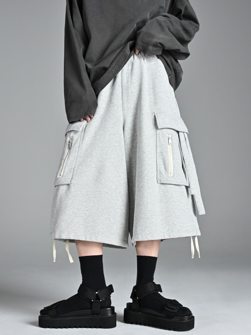 グレー系のTシャツ/カットソー、ブラック系のサンダル、グレー系のカーゴパンツを着用したメンズの夏コーディネートの2枚目の写真