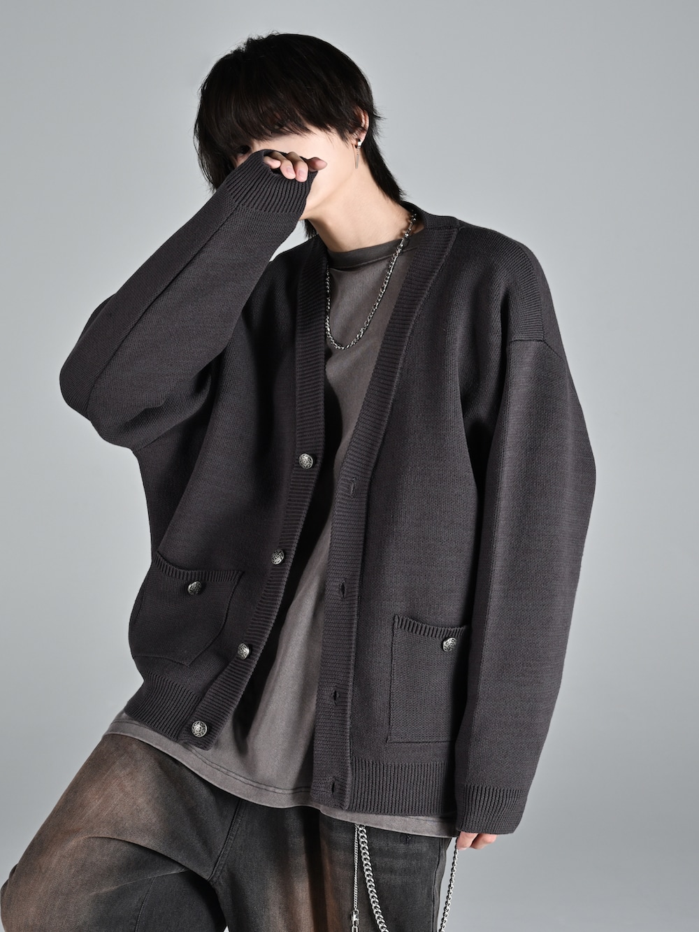 グレー系のTシャツ/カットソー、グレー系のカーディガン/ボレロ、ブラック系のデニムパンツを着用したメンズの冬コーディネートの2枚目の写真