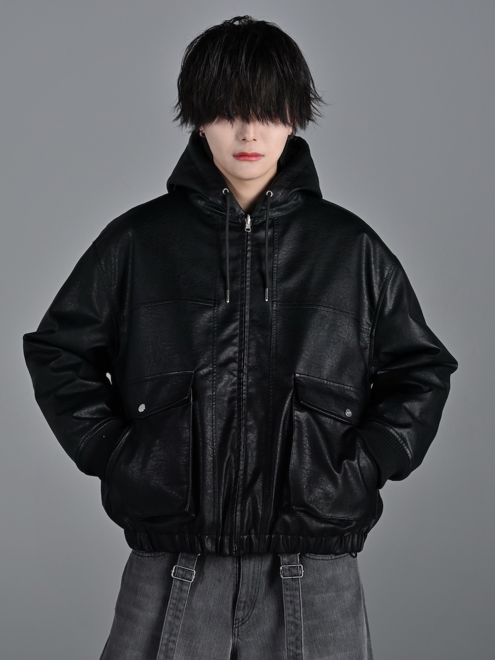 ブラック系のブルゾン、グレー系のスウェット、グレー系のデニムパンツを着用したメンズの冬コーディネートの4枚目の写真