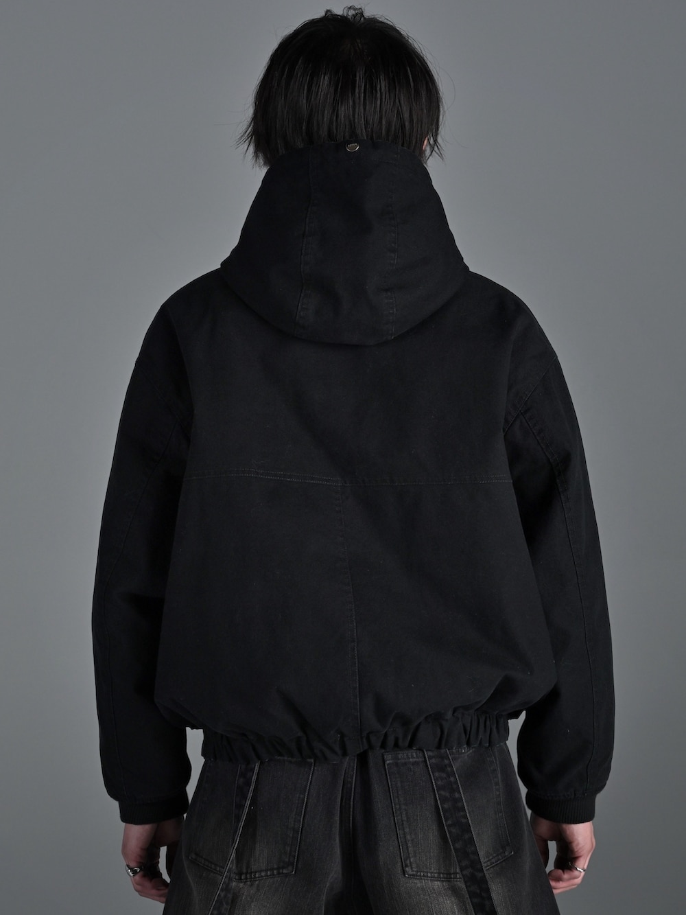 ブラック系のブルゾン、ブラック系のデニムパンツ、グレー系のスウェットを着用したメンズの冬コーディネートの3枚目の写真