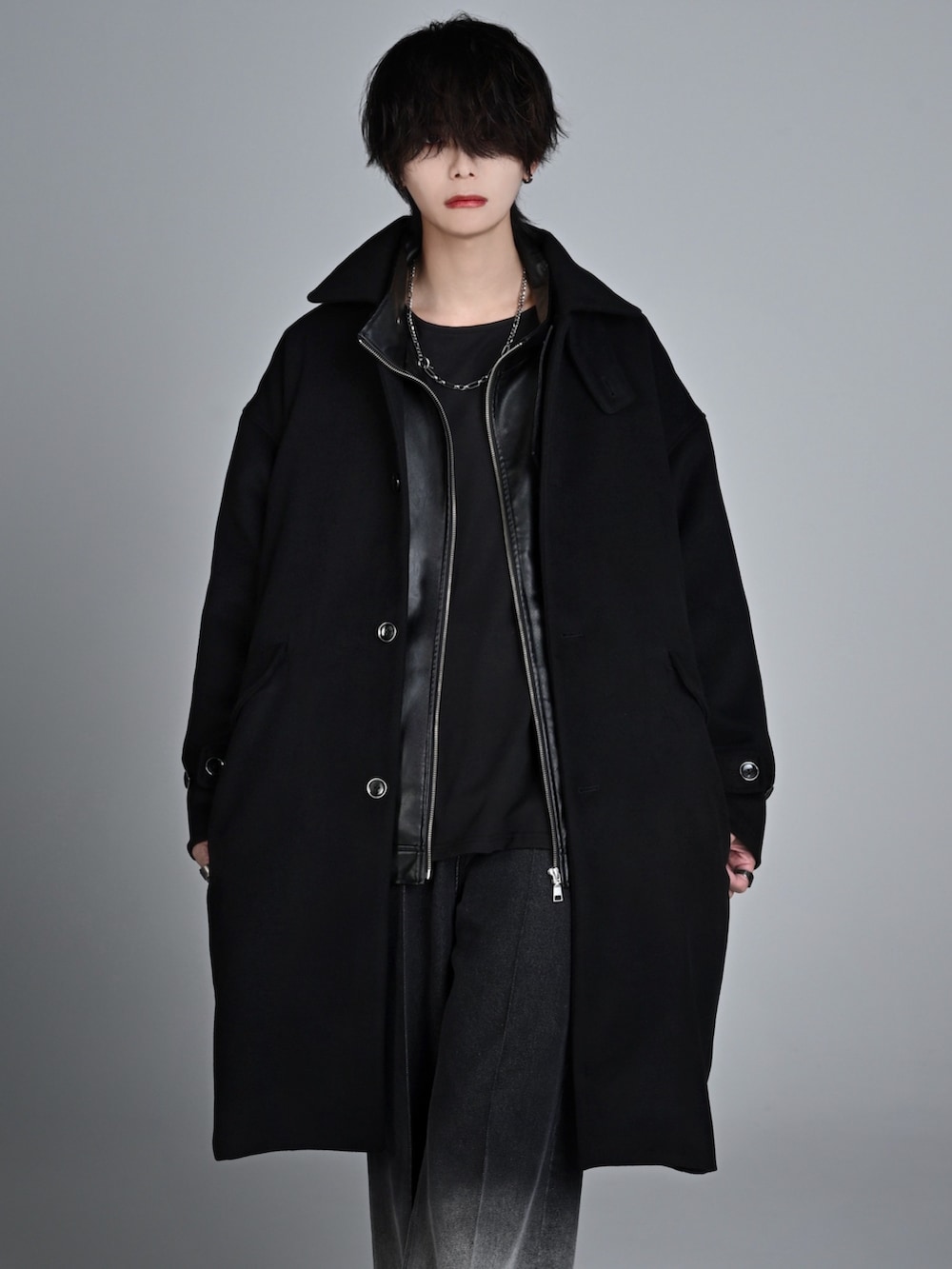 ブラック系のタンクトップ、ブラック系のブーツ、ブラック系のステンカラーコートを着用したメンズの秋コーディネートの2枚目の写真