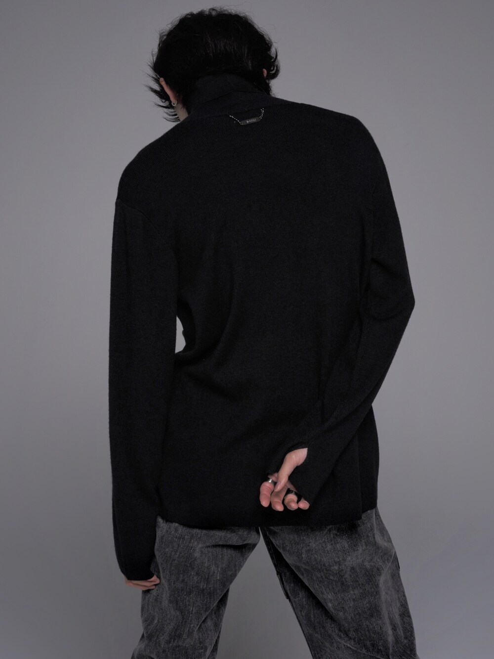 ブラック系のデニムパンツ、ブラック系のブーツ、ブラック系のニット/セーターを着用したメンズの秋コーディネートの5枚目の写真