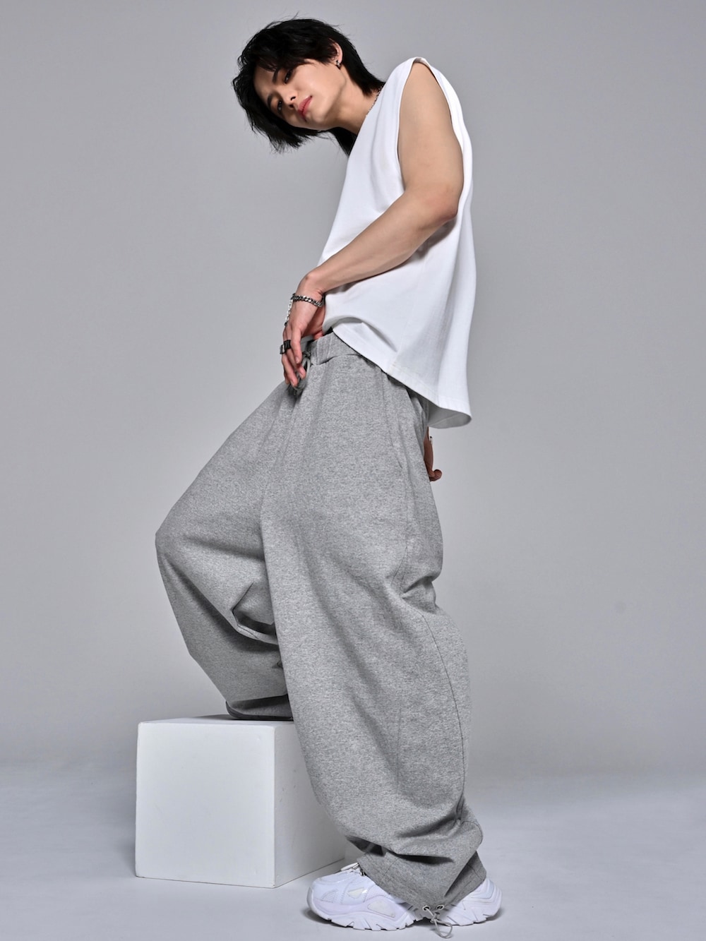 ホワイト系のタンクトップ、ホワイト系のスニーカー、グレー系のスウェットパンツを着用したメンズの夏コーディネートの3枚目の写真