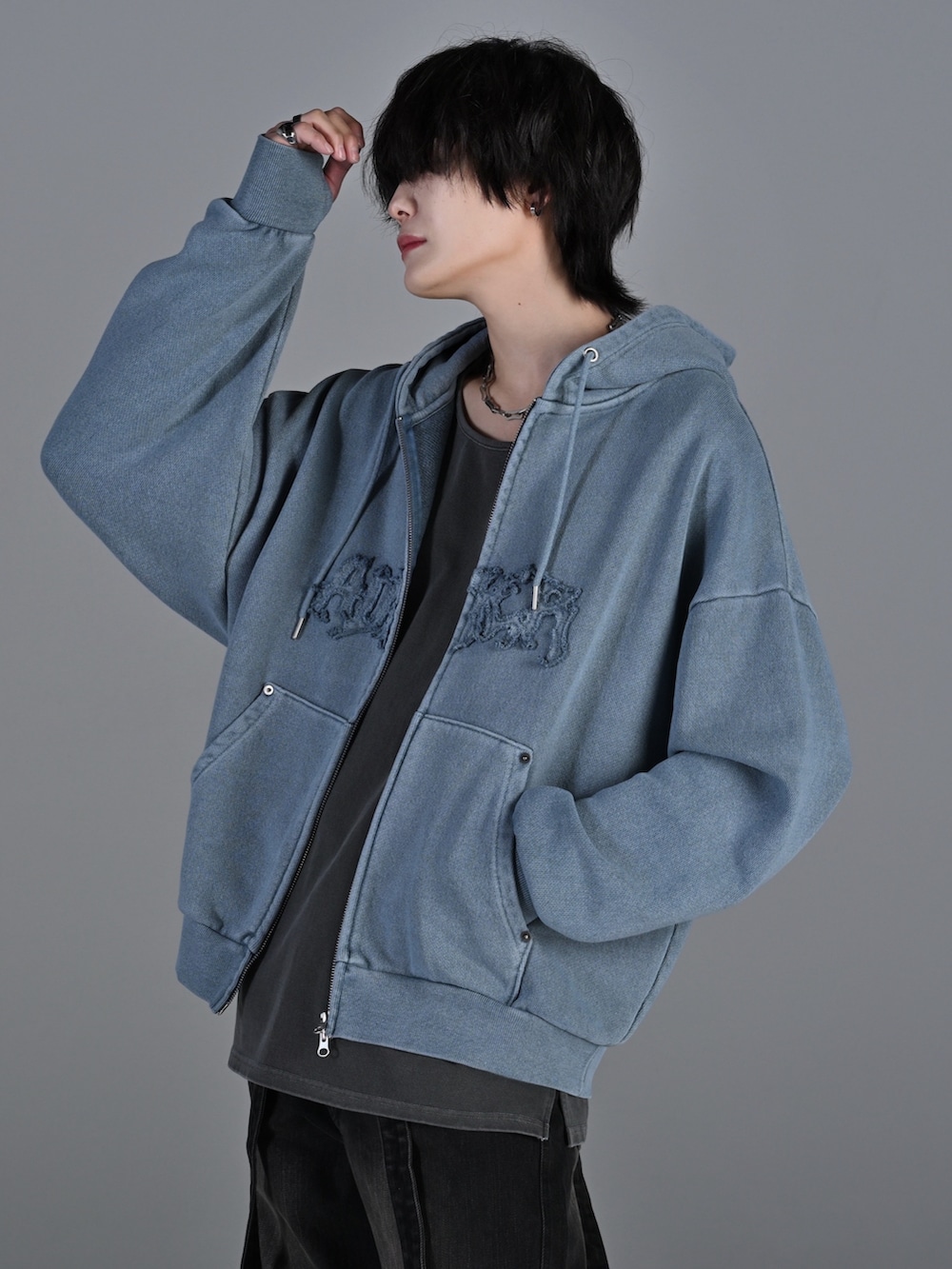 ブラック系のデニムパンツ、ホワイト系のスニーカー、ブラック系のショルダーバッグを着用したメンズの冬コーディネートの3枚目の写真