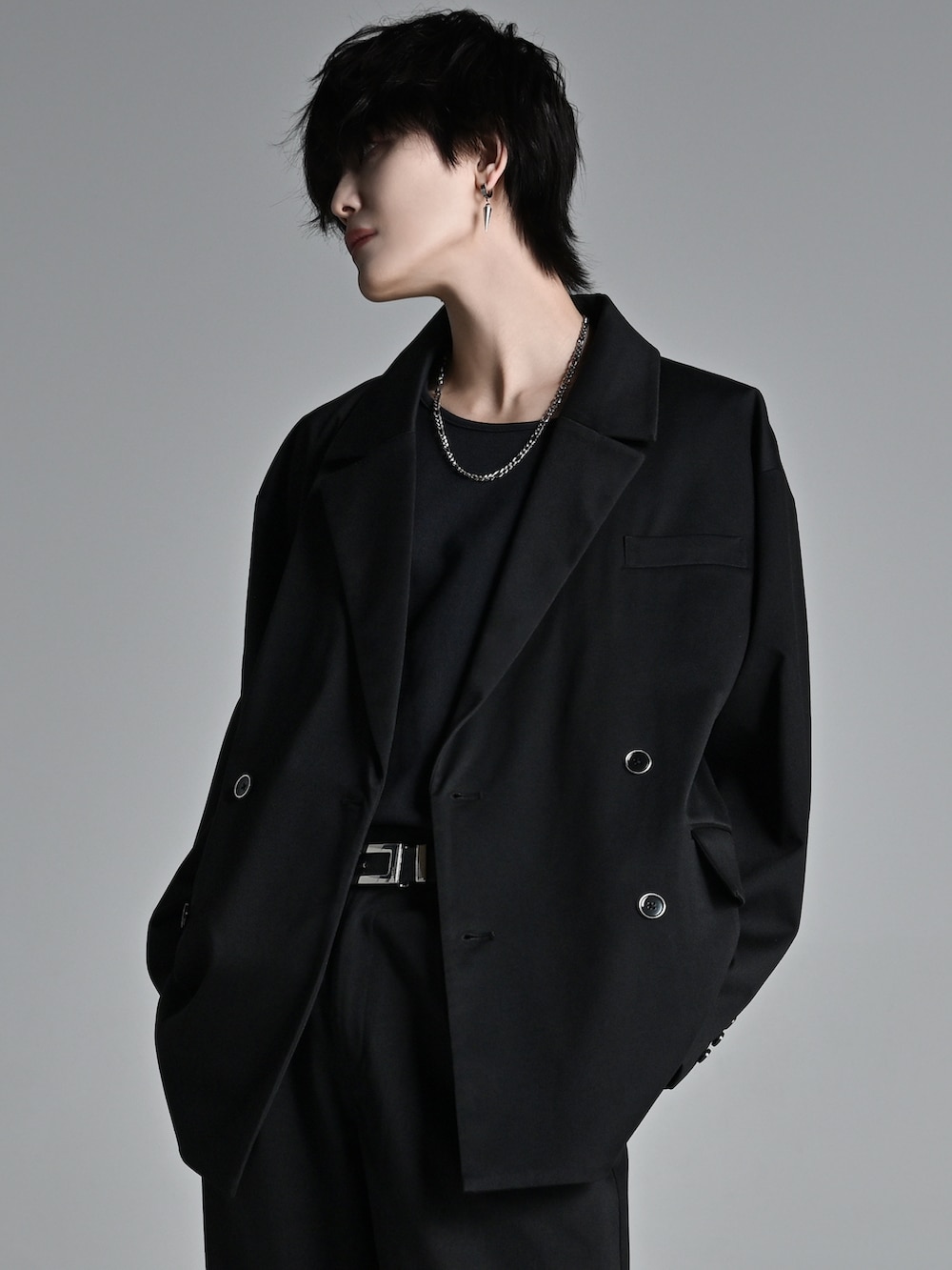 ブラック系のテーラードジャケット、レッド系のタンクトップ、ブラック系のスラックスを着用したメンズの冬コーディネートの4枚目の写真