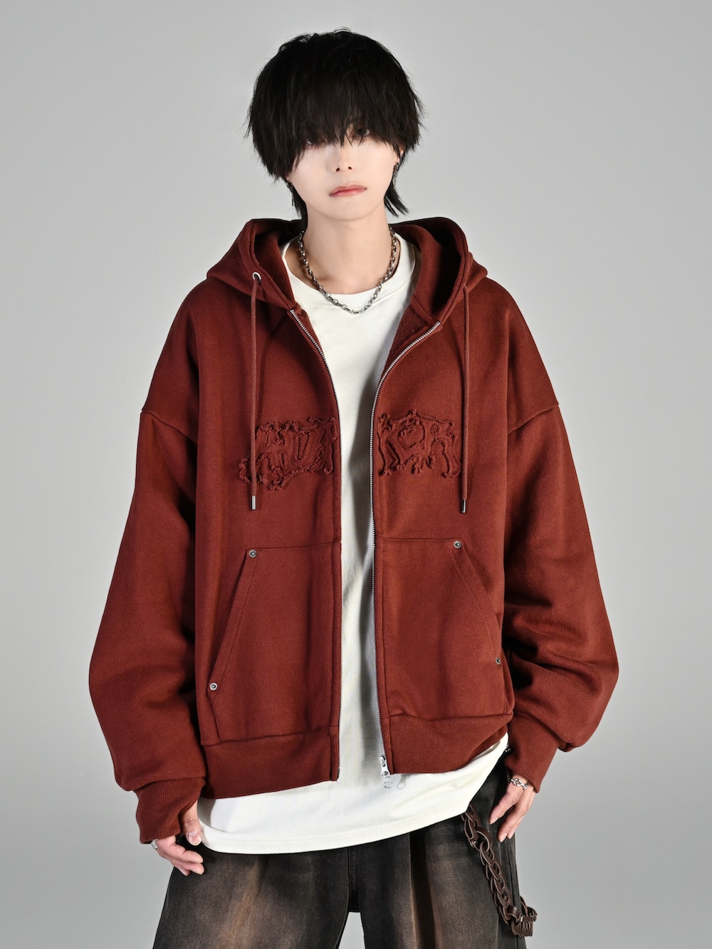 レッド系のタンクトップ、グレー系のパーカー、ブルー系のデニムパンツを着用したメンズの秋コーディネートの4枚目の写真