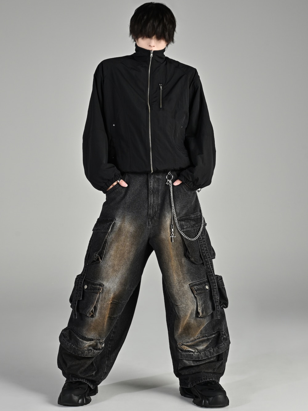 ベージュ系のブーツ、ブラック系のブルゾン、グレー系のスウェットパンツを着用したメンズの秋コーディネートの4枚目の写真