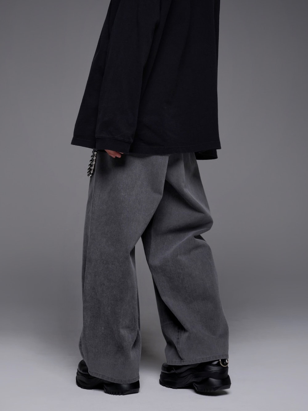 ブラック系のTシャツ/カットソー、ブルー系のデニムパンツ、ブラック系のスニーカーを着用したメンズの冬コーディネートの5枚目の写真