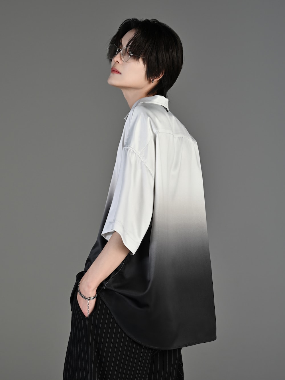 ブラック系のスラックス、ブラック系のブーツ、ブラック系のシャツ/ブラウスを着用したメンズの春コーディネートの4枚目の写真