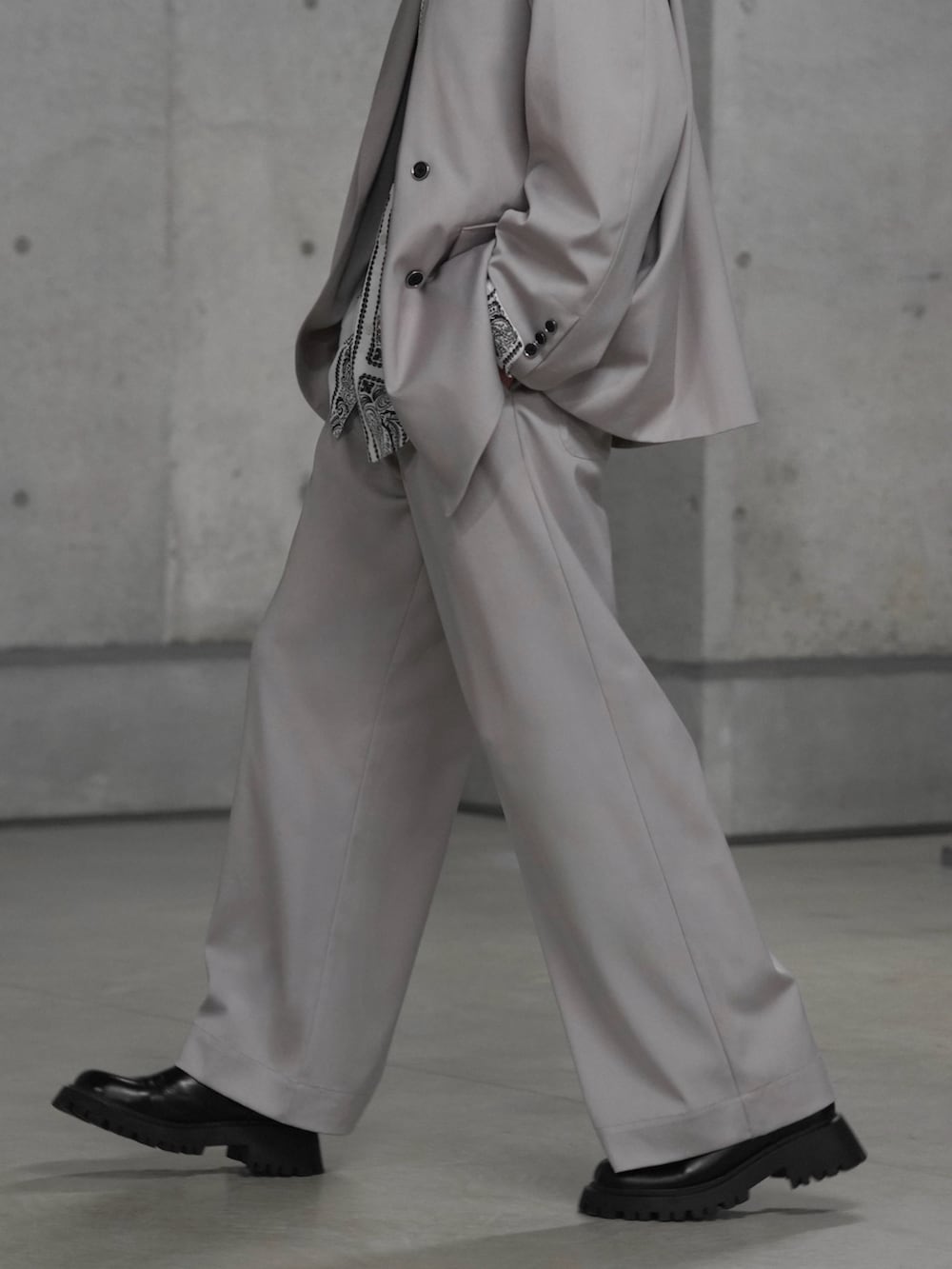 ブラック系のブーツ、グレー系のテーラードジャケット、グレー系のスラックスを着用したメンズの冬コーディネートの4枚目の写真