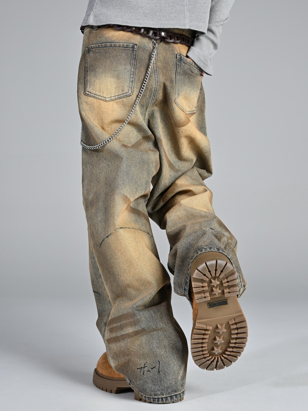 ベージュ系のブーツ、ブラック系のジャケット/アウター、ブルー系のデニムパンツを着用したメンズの冬コーディネートの4枚目の写真