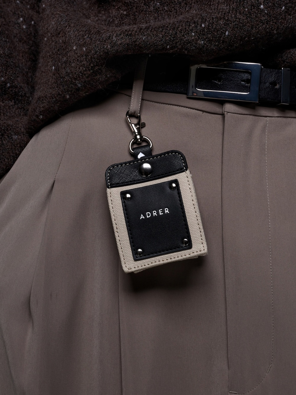 ベージュ系のスラックス、ブラック系のブーツ、ブラウン系のニット/セーターを着用したメンズの秋コーディネートの5枚目の写真