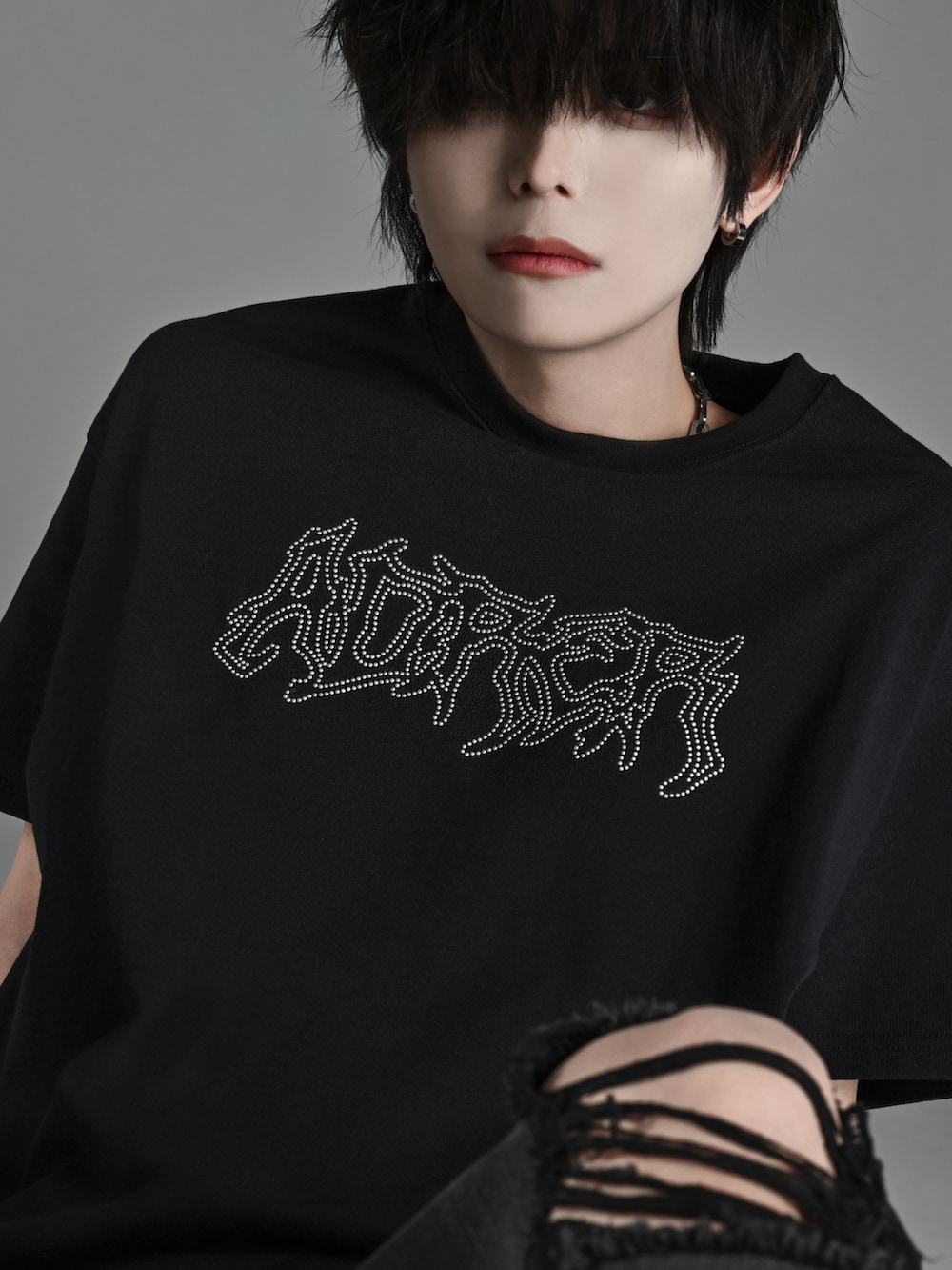 ブラック系のスニーカー、ブラック系のTシャツ/カットソー、ブラック系のデニムパンツを着用したメンズの春コーディネートの2枚目の写真