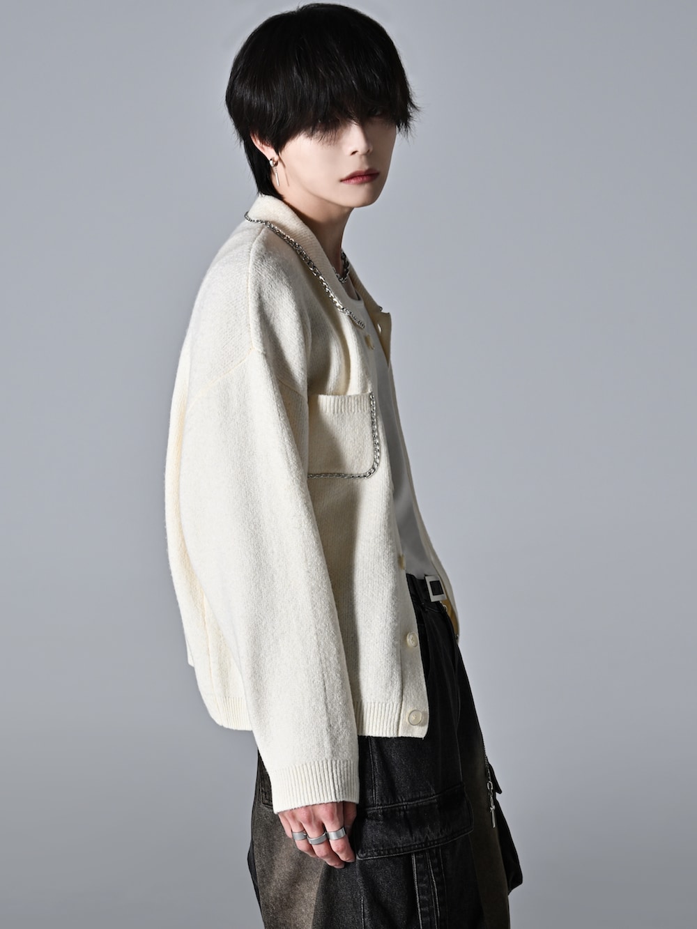 ブラック系のスラックス、ブラック系のローファー、ホワイト系のカーディガン/ボレロを着用したメンズの秋コーディネートの3枚目の写真