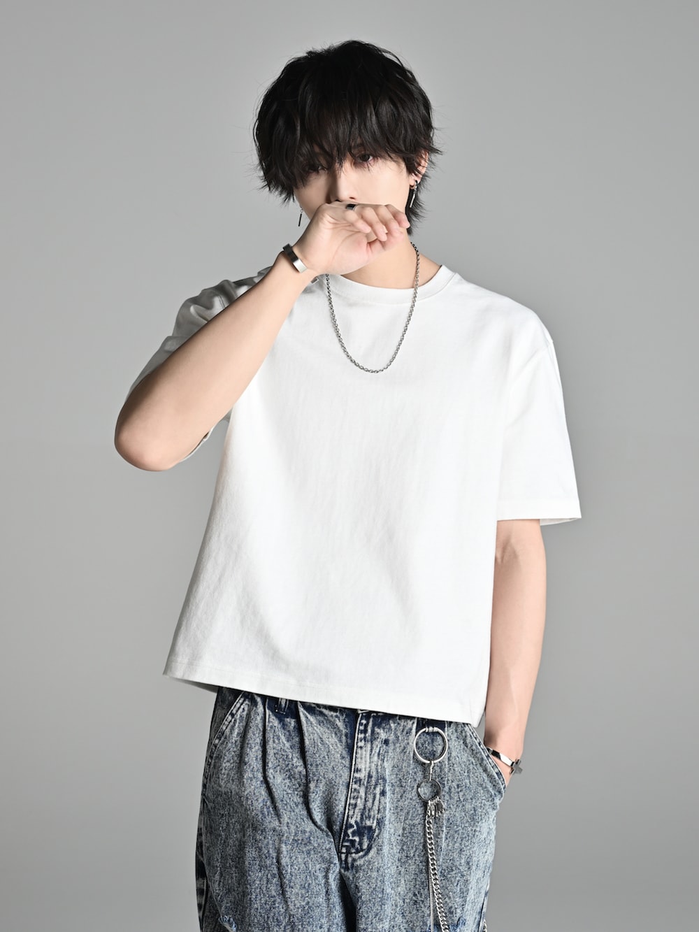 ホワイト系のTシャツ/カットソー、ブルー系のデニムパンツ、ブラック系のブーツを着用したメンズの春コーディネートの2枚目の写真