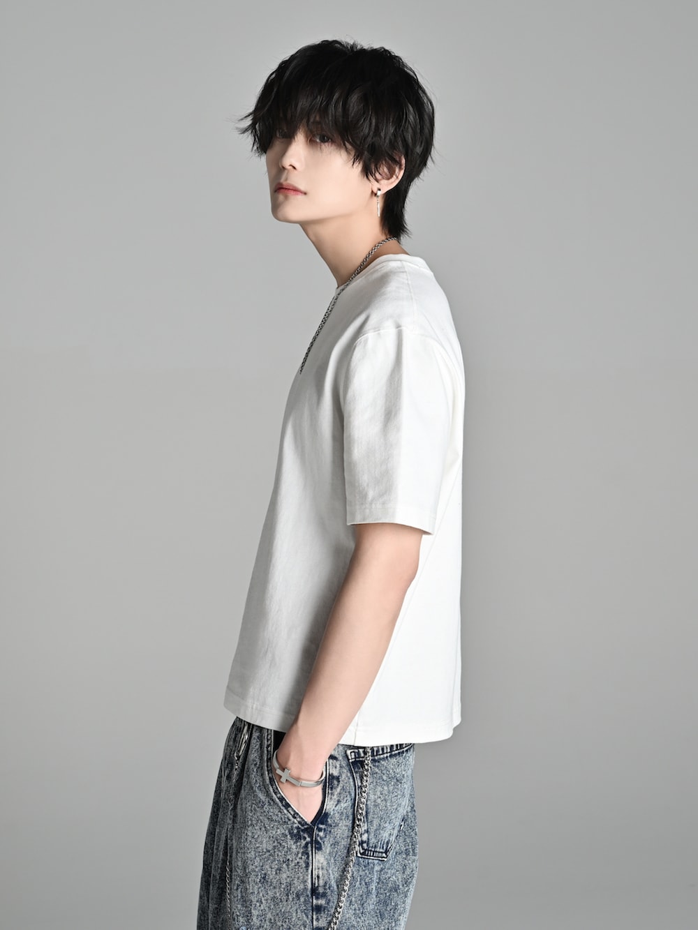 ホワイト系のTシャツ/カットソー、ブルー系のデニムパンツ、ブラック系のブーツを着用したメンズの春コーディネートの3枚目の写真