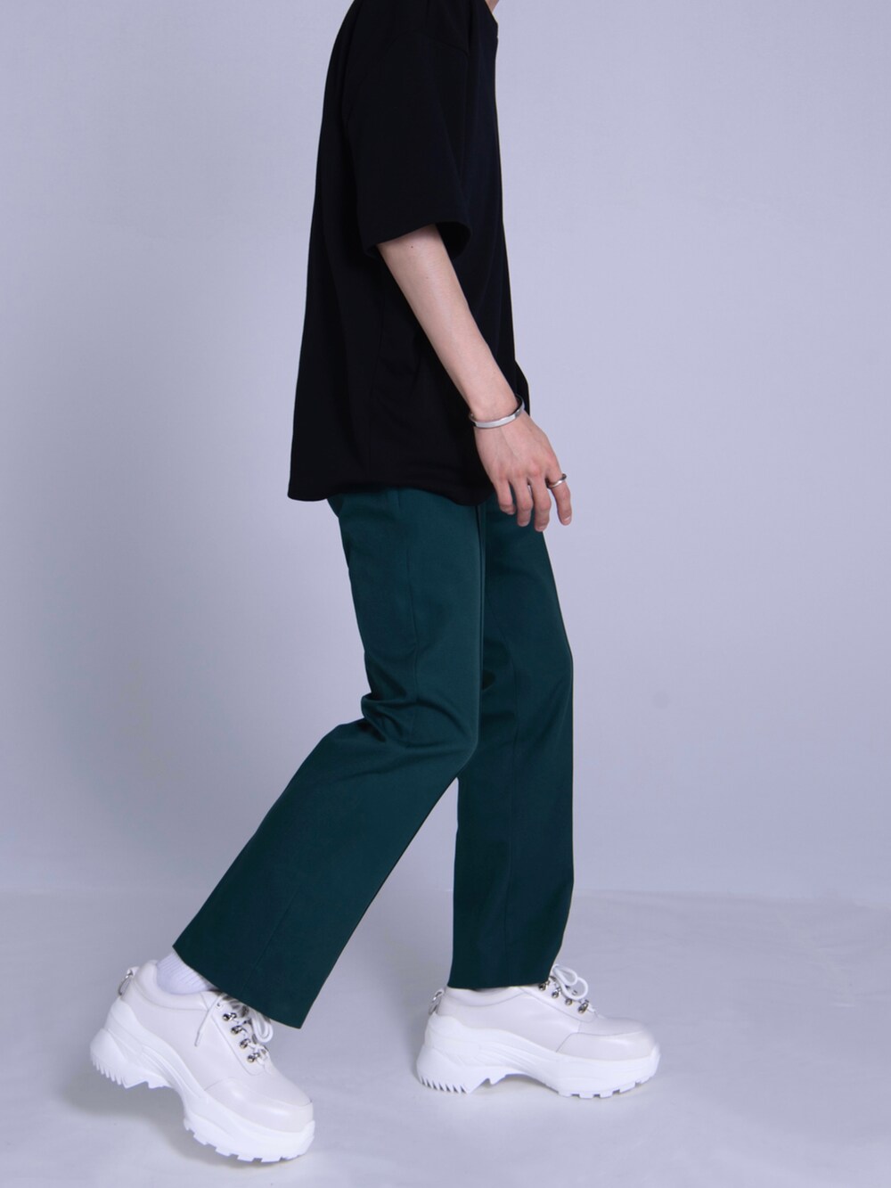 ホワイト系のスニーカー、ブラック系のTシャツ/カットソー、ホワイト系のショルダーバッグを着用したメンズの春コーディネートの4枚目の写真