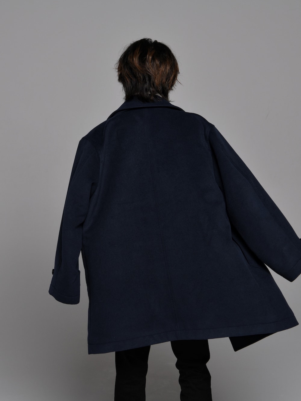 ブラック系のスラックス、ブラック系のブーツ、ホワイト系のニット/セーターを着用したメンズの秋コーディネートの5枚目の写真