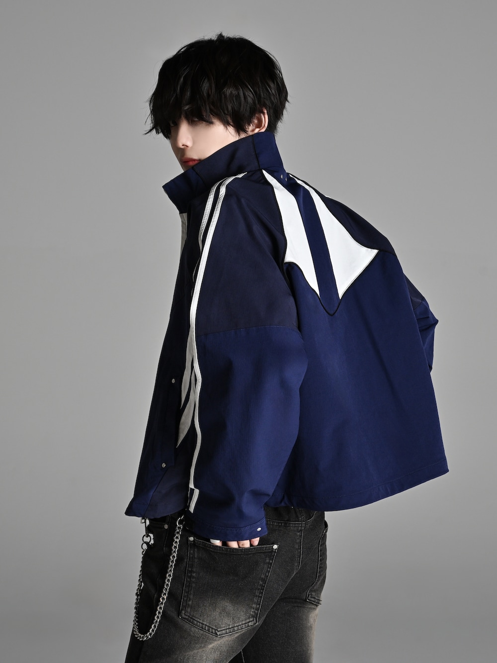 ブルー系のナイロンジャケット、ブラック系のデニムパンツ、ブラック系のショルダーバッグを着用したメンズの冬コーディネートの3枚目の写真