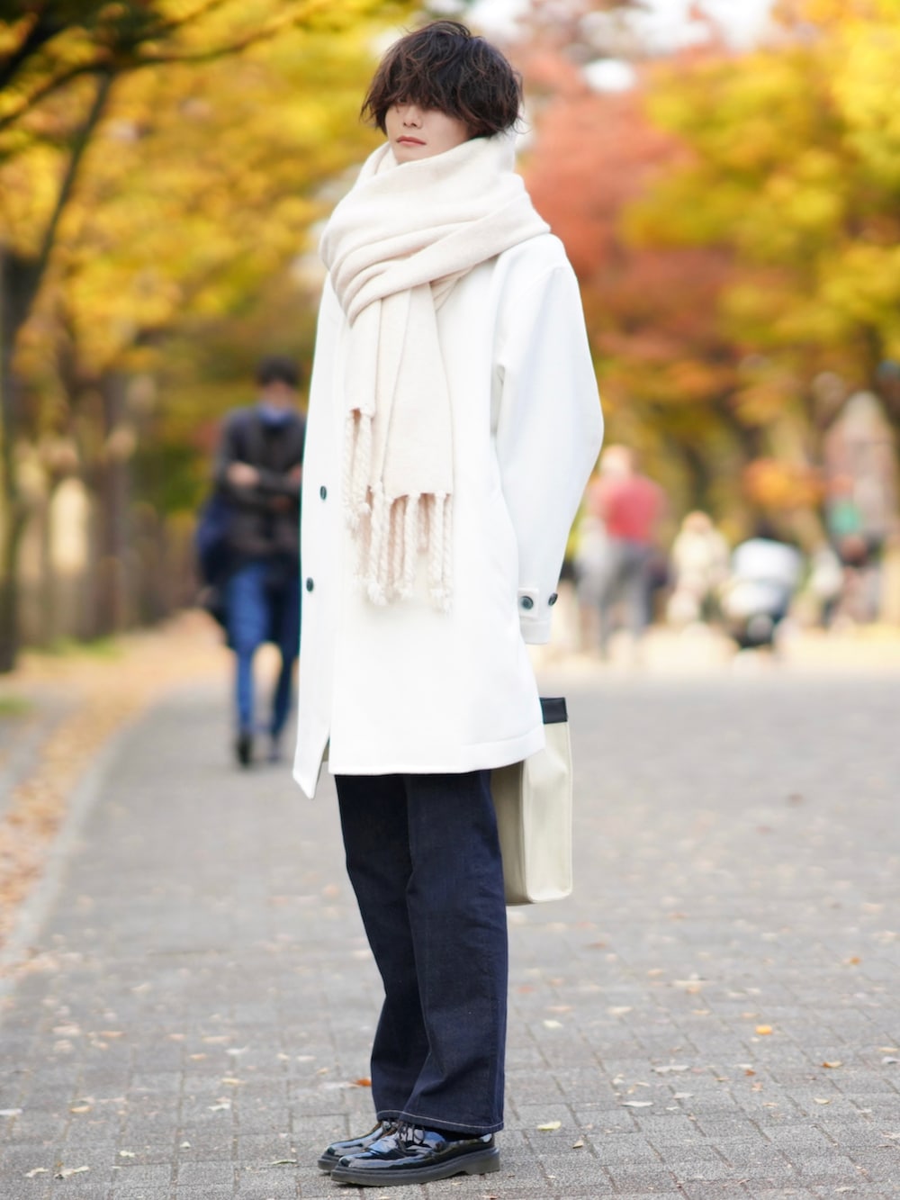 ブルー系のデニムパンツ、グリーン系のニット/セーター、ベージュ系のトートバッグを着用したメンズの秋コーディネートの4枚目の写真