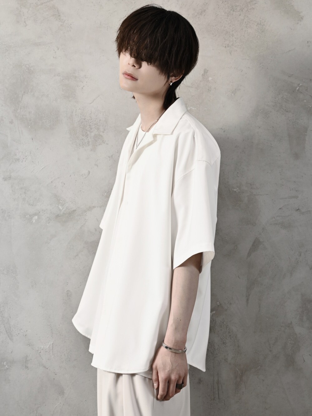 ホワイト系のタンクトップ、ホワイト系のスラックス、ブラック系のショルダーバッグを着用したメンズの春コーディネートの4枚目の写真