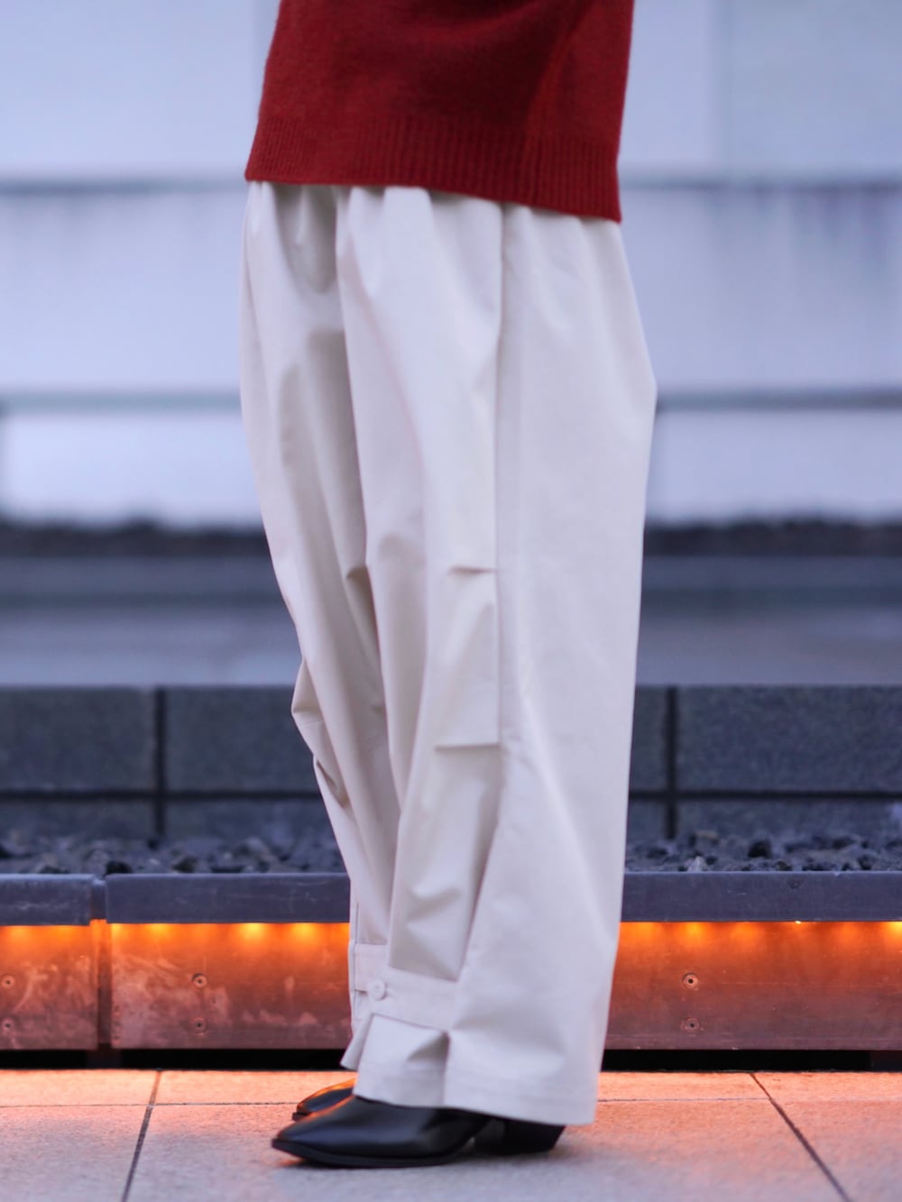 ブラック系のブーツ、オレンジ系のニット/セーター、ホワイト系のその他パンツを着用したメンズの秋コーディネートの5枚目の写真