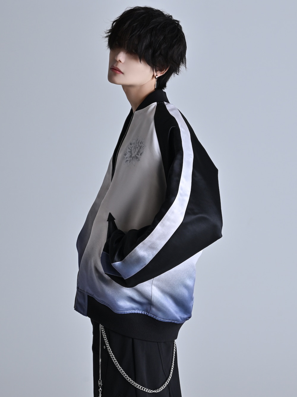 ブラック系のスウェットパンツ、ブラック系のスニーカー、ブラック系のスカジャンを着用したメンズの冬コーディネートの3枚目の写真