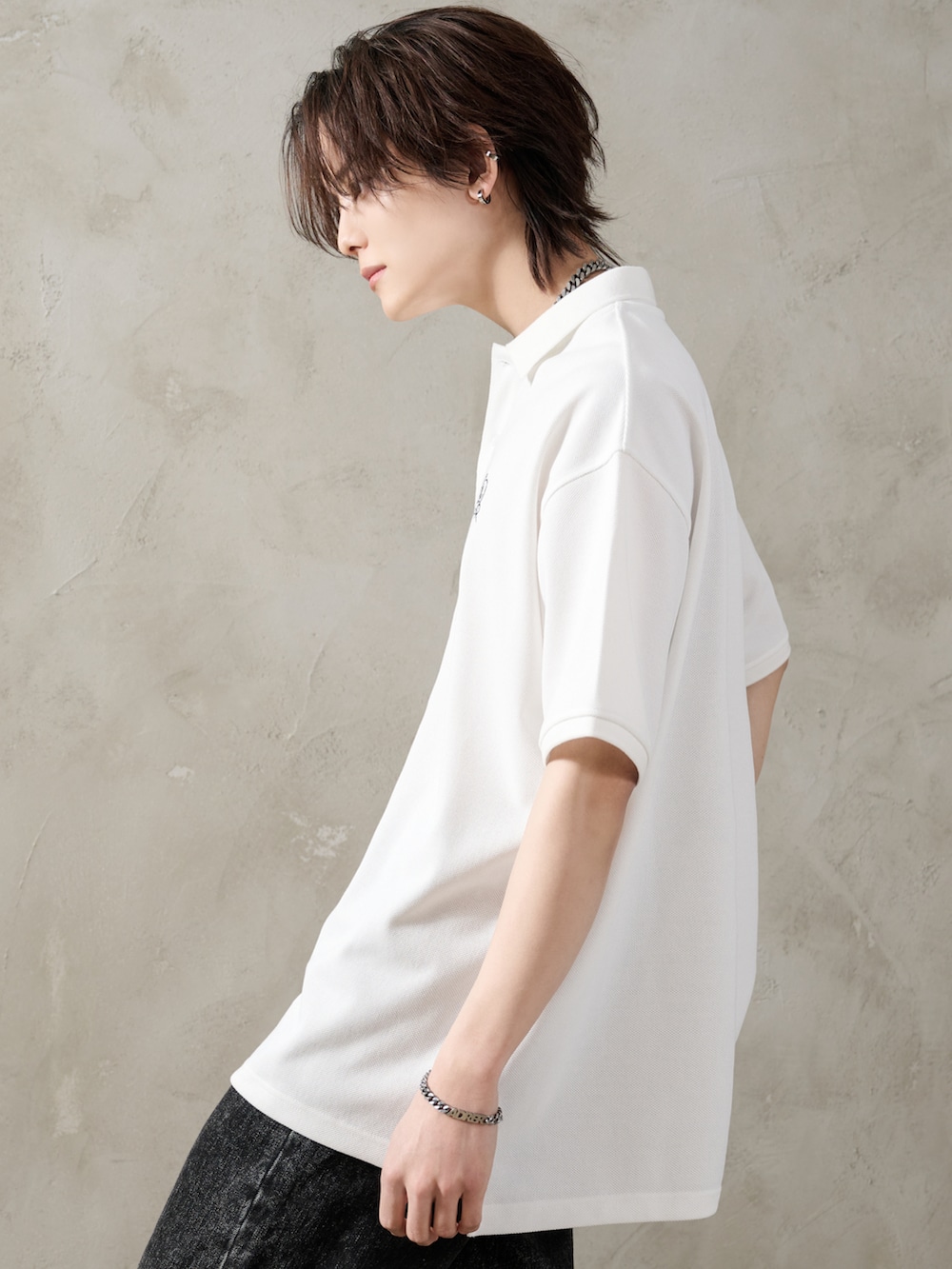 ブラック系のデニムパンツ、ブラック系のブーツ、ブラック系のショルダーバッグを着用したメンズの春コーディネートの3枚目の写真