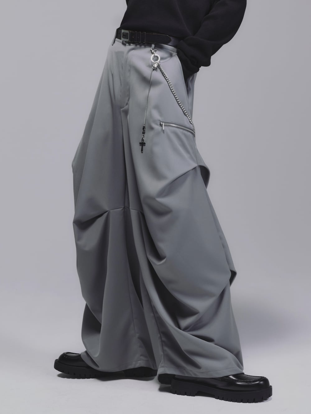 ブラック系のTシャツ/カットソー、グレー系のスラックス、ブラック系のローファーを着用したメンズの冬コーディネートの2枚目の写真