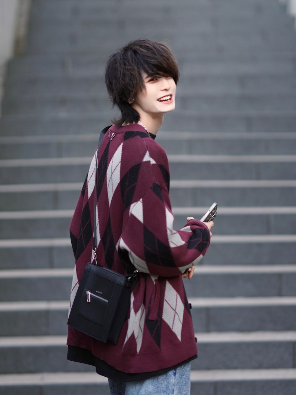 ブラック系のTシャツ/カットソー、ブルー系のデニムパンツ、ブラック系のスニーカーを着用したメンズの秋コーディネートの4枚目の写真