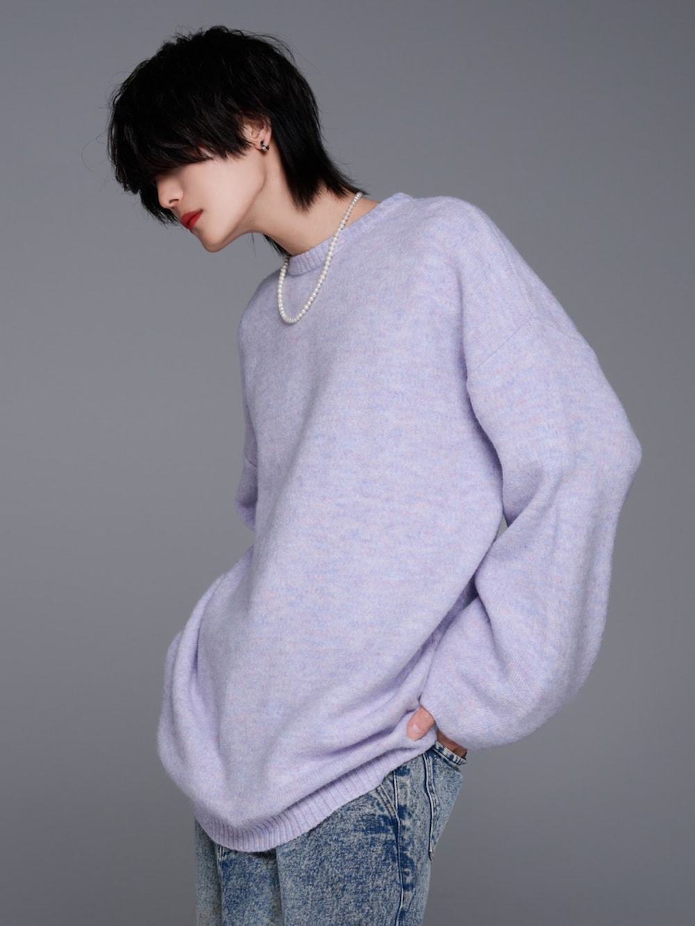 ブルー系のデニムパンツ、ブラック系のスニーカー、パープル系のニット/セーターを着用したメンズの秋コーディネートの3枚目の写真