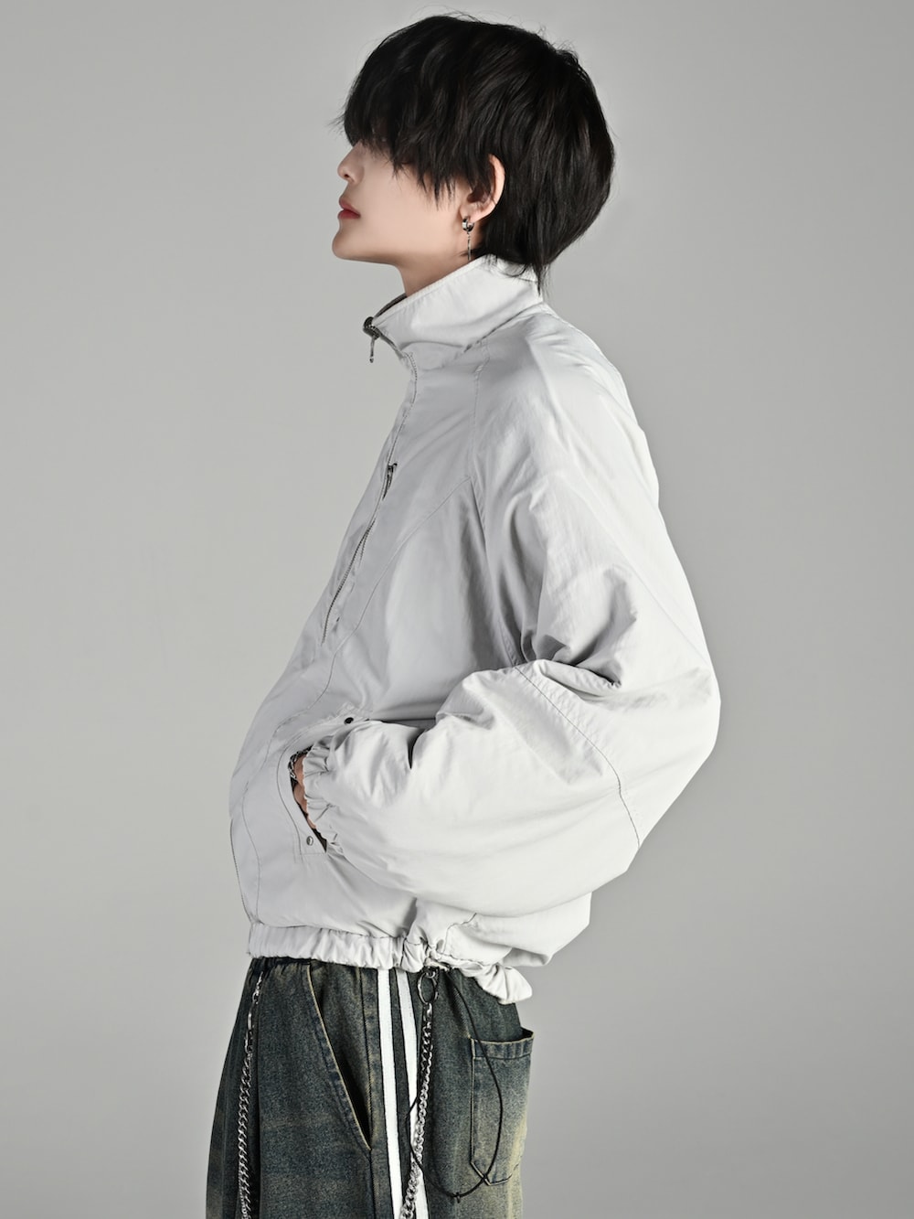 ベージュ系のブーツ、ホワイト系のブルゾン、グレー系のスウェットパンツを着用したメンズの秋コーディネートの4枚目の写真