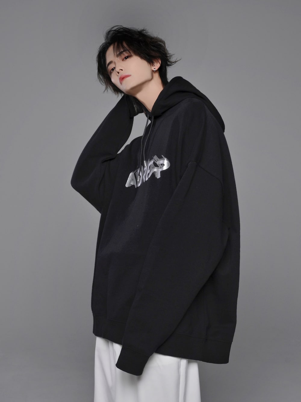 ブラック系のスニーカー、シルバー系のパーカー、ブラック系のカーゴパンツを着用したメンズの冬コーディネートの4枚目の写真