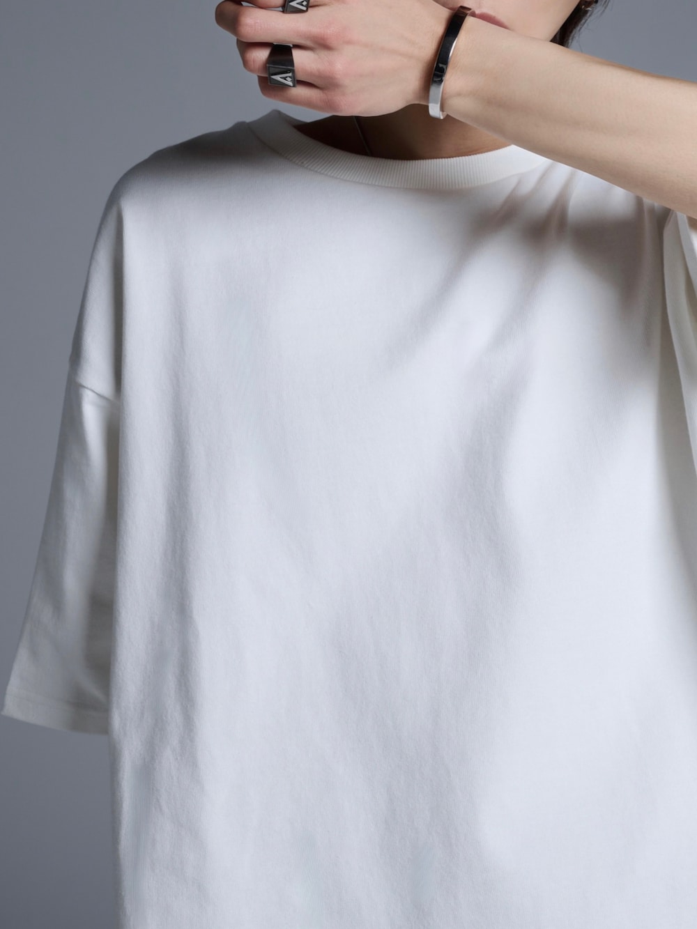 ブラック系のカーゴパンツ、ブラック系のスニーカー、ホワイト系のTシャツ/カットソーを着用したメンズの春コーディネートの2枚目の写真