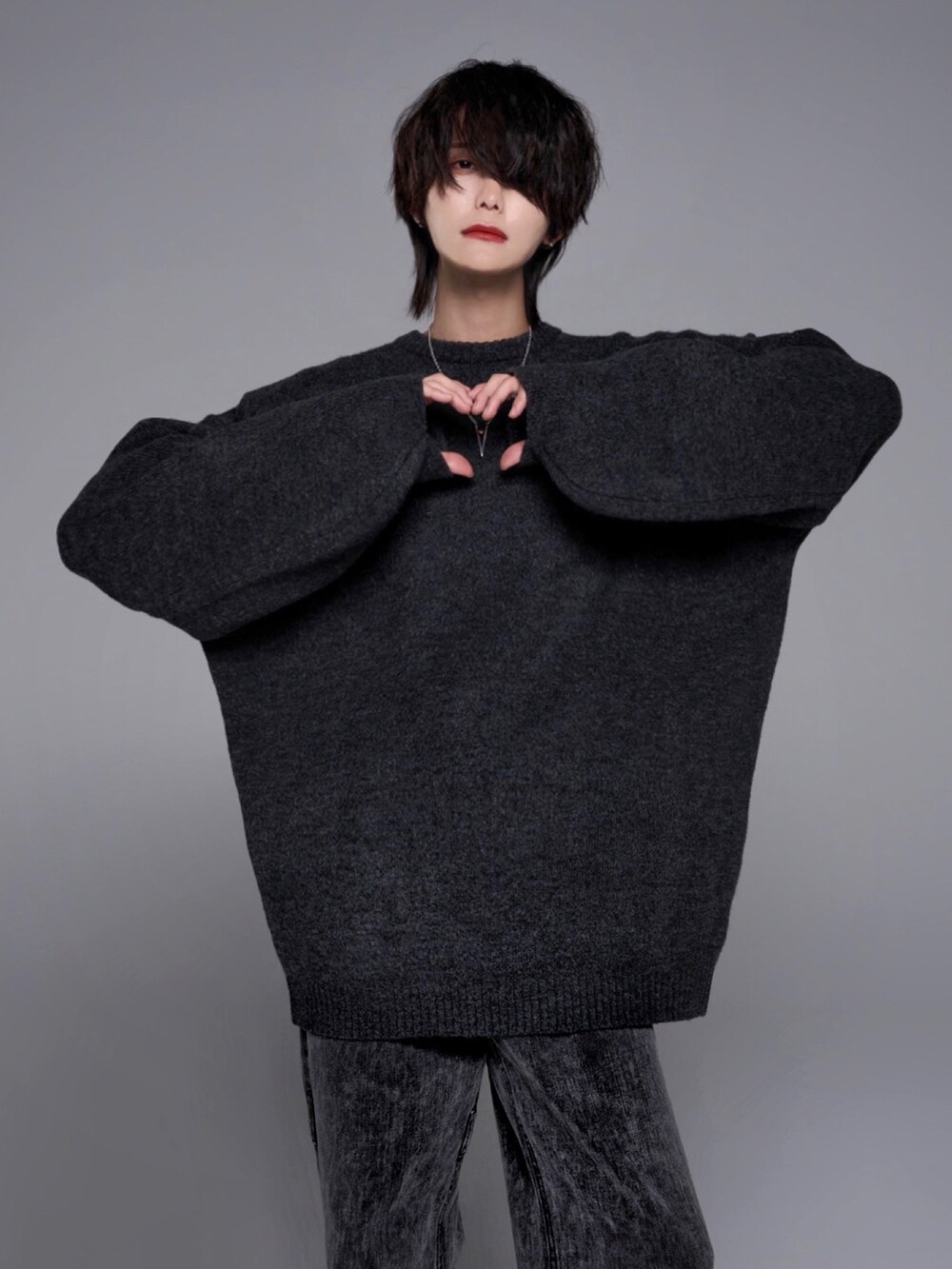 ブラック系のデニムパンツ、ブラック系のローファー、ブラック系のニット/セーターを着用したメンズの秋コーディネートの2枚目の写真