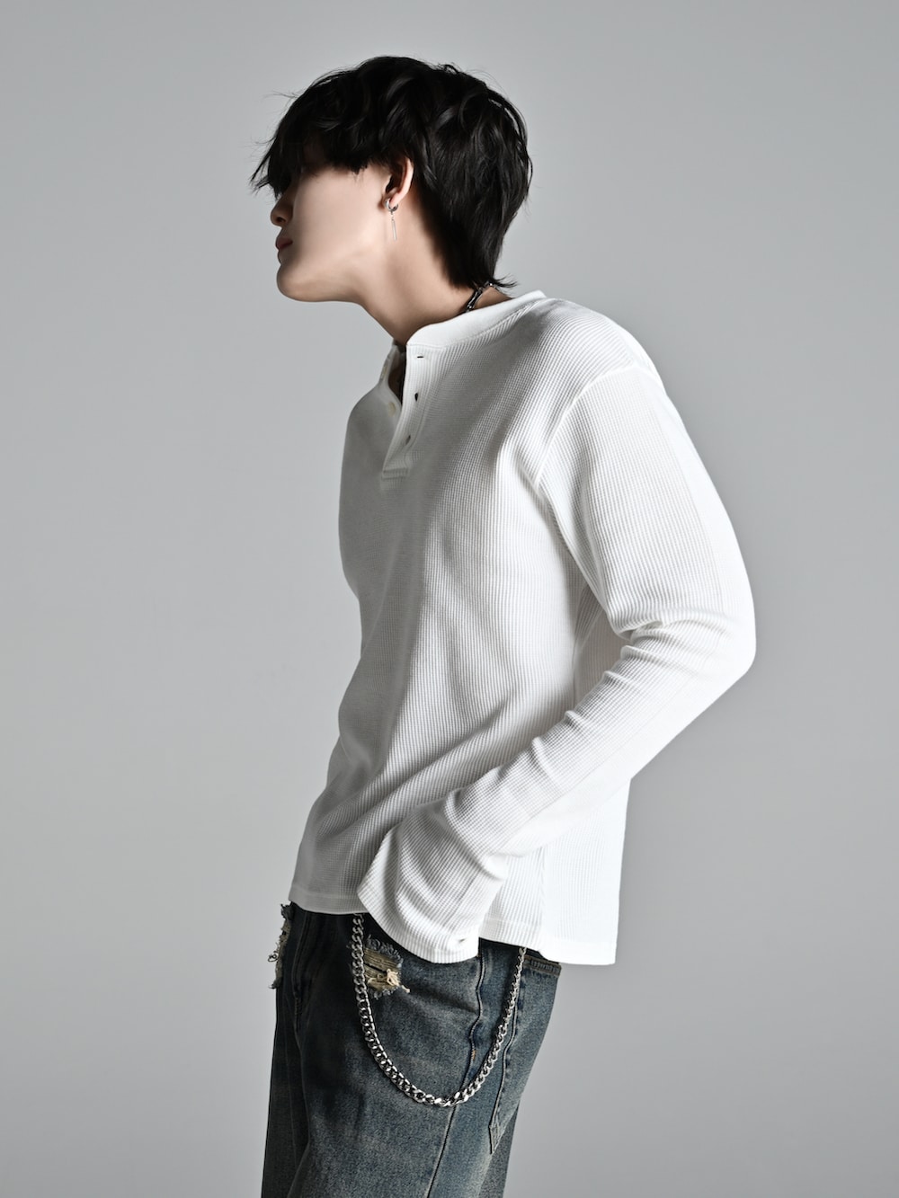 ブルー系のデニムパンツ、ブラック系のショルダーバッグ、ブラック系のブーツを着用したメンズの冬コーディネートの3枚目の写真