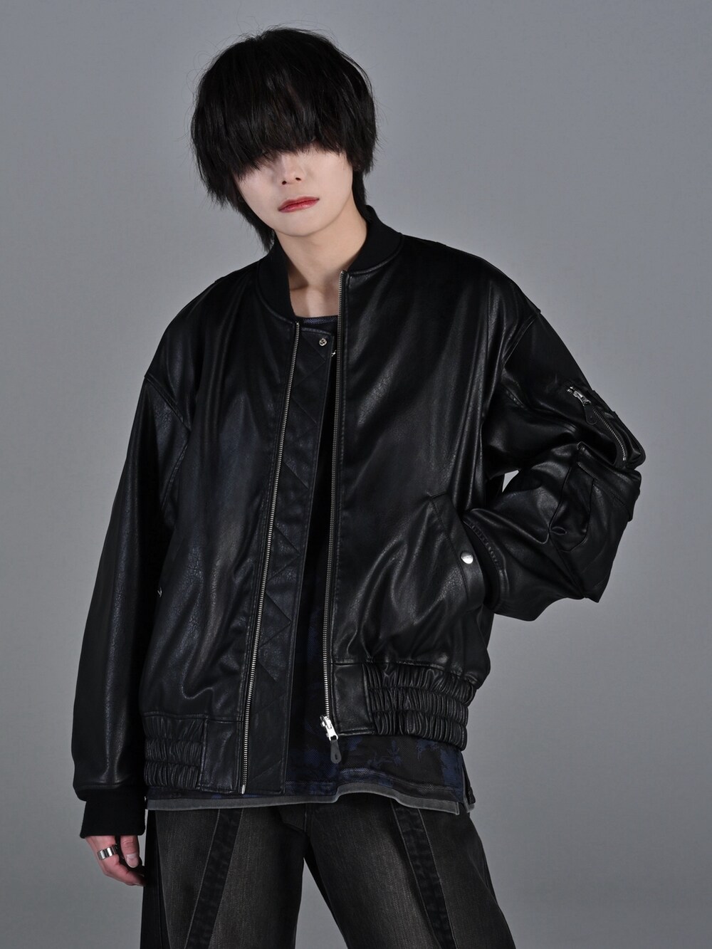 ブラック系のデニムパンツ、ブラック系のブーツ、レッド系のタンクトップを着用したメンズの冬コーディネートの4枚目の写真