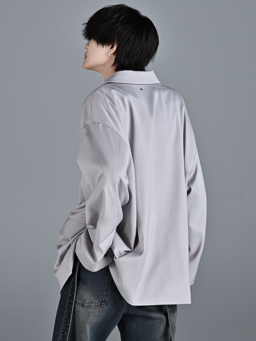 ブルー系のデニムパンツ、レッド系のタンクトップ、グレー系のテーラードジャケットを着用したメンズの冬コーディネートの4枚目の写真